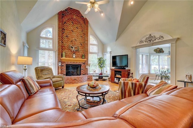 living room with high vaulted ceiling, wood-type flooring, a fireplace, and ceiling fan