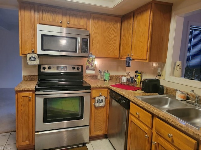 kitchen featuring sink, appliances with stainless steel finishes, decorative backsplash, and light tile patterned flooring