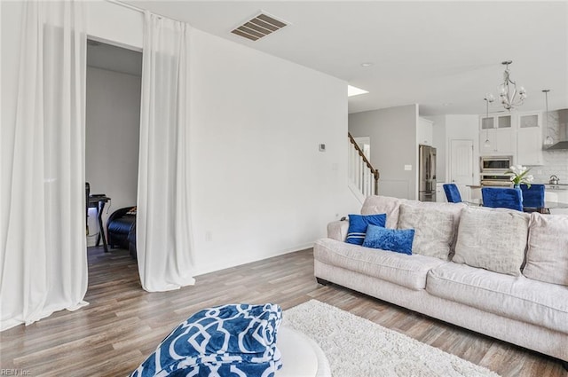 living room featuring a notable chandelier and wood-type flooring