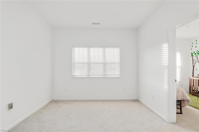 unfurnished room featuring light colored carpet