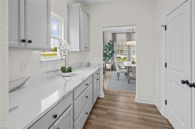 kitchen with dark wood-type flooring and light stone counters