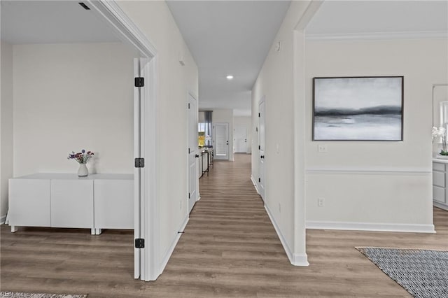 corridor with crown molding and hardwood / wood-style floors