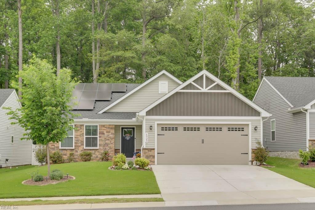 craftsman house featuring a garage, a front yard, and solar panels