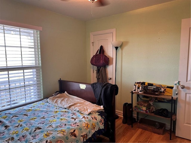 bedroom with ceiling fan, light hardwood / wood-style floors, and multiple windows