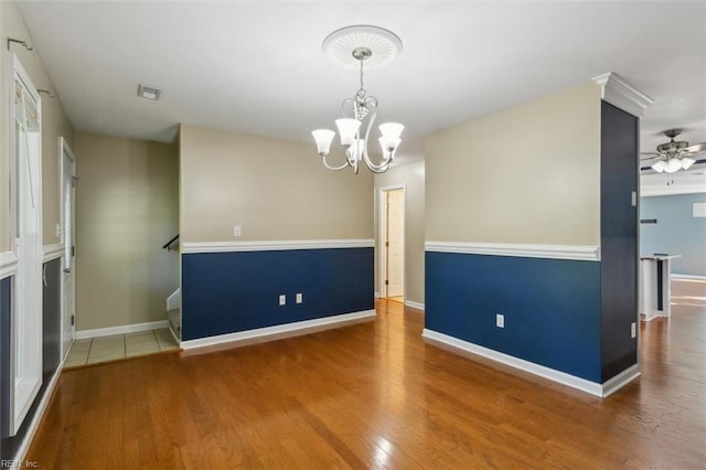 spare room featuring ceiling fan with notable chandelier and wood-type flooring