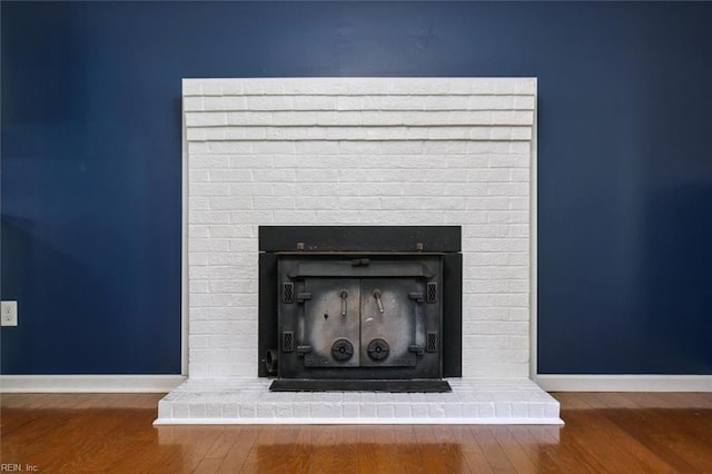 interior details with a brick fireplace and hardwood / wood-style floors