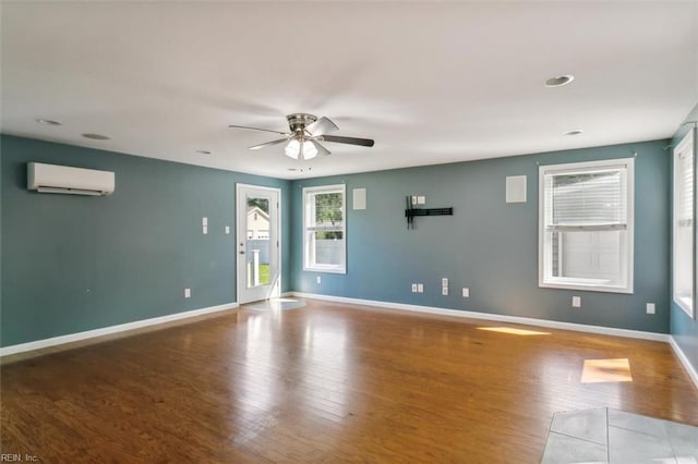 unfurnished room featuring ceiling fan, light hardwood / wood-style floors, and an AC wall unit