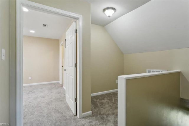 hall featuring light carpet and vaulted ceiling