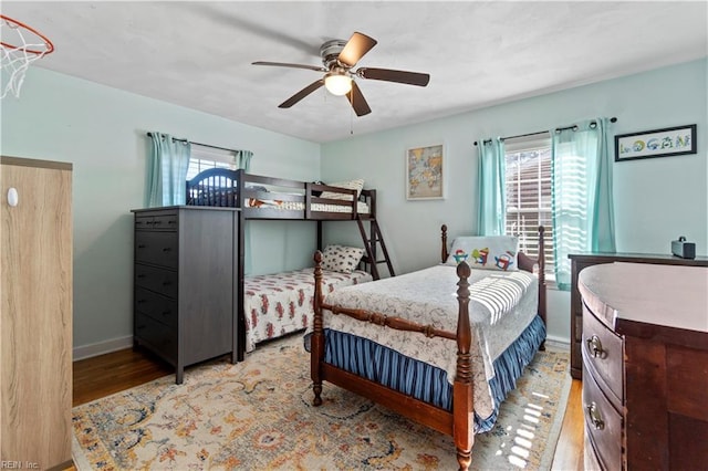 bedroom featuring ceiling fan, multiple windows, and light hardwood / wood-style flooring