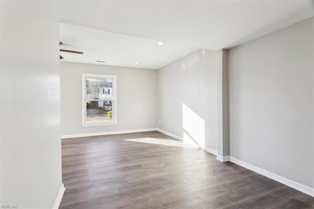 empty room with ceiling fan and dark wood-type flooring