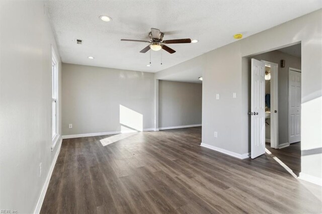 spare room featuring a textured ceiling, dark wood-type flooring, and ceiling fan