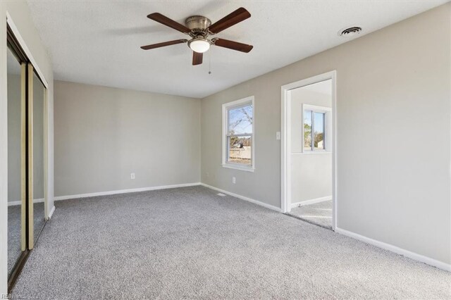 unfurnished bedroom with ceiling fan, carpet flooring, and a closet