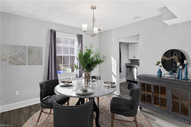 dining space with hardwood / wood-style flooring and a notable chandelier