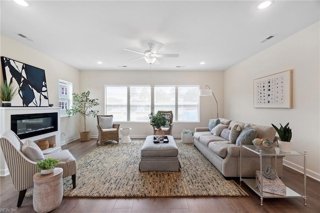 living room with ceiling fan and dark hardwood / wood-style floors