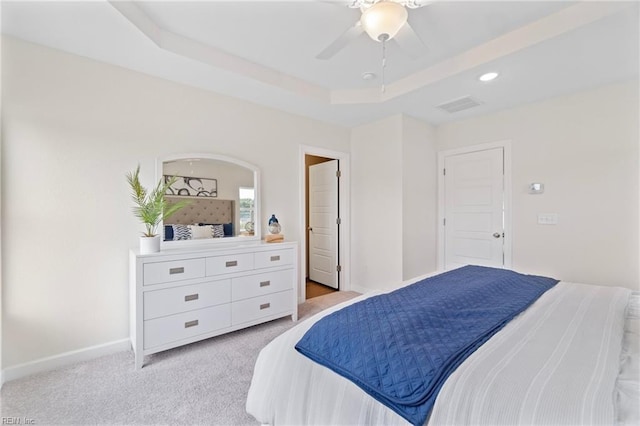 bedroom featuring ceiling fan, light carpet, and a raised ceiling