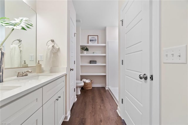 bathroom with toilet, hardwood / wood-style floors, and vanity