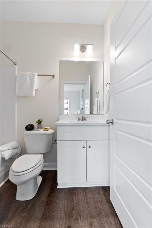 bathroom with toilet, vanity, and hardwood / wood-style floors