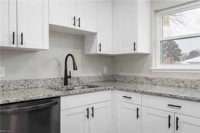 kitchen featuring light stone counters, sink, white cabinetry, and stainless steel dishwasher