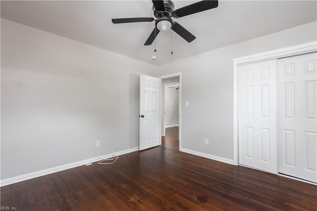 unfurnished bedroom with dark wood-type flooring, a closet, and ceiling fan