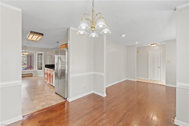 unfurnished dining area featuring a notable chandelier and light hardwood / wood-style floors