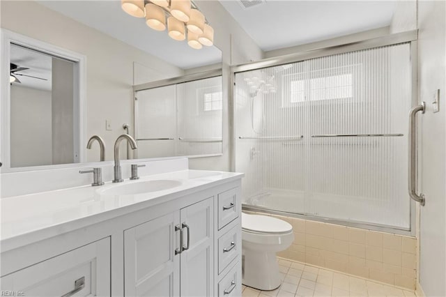 full bathroom with toilet, tile patterned floors, vanity, and shower / bath combination with glass door