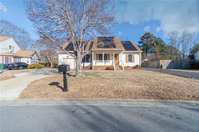 view of front facade featuring a garage, a porch, and solar panels