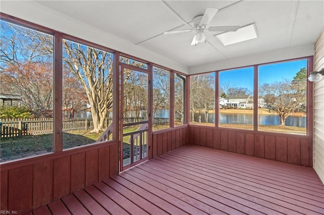 unfurnished sunroom featuring ceiling fan, plenty of natural light, and a water view