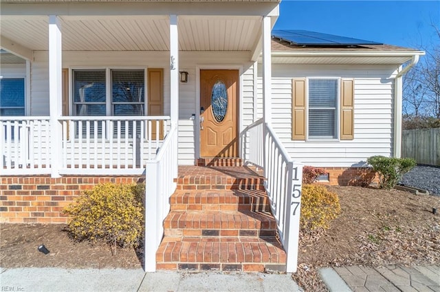 entrance to property featuring solar panels and a porch