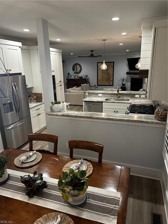 kitchen featuring white cabinetry, sink, pendant lighting, and appliances with stainless steel finishes