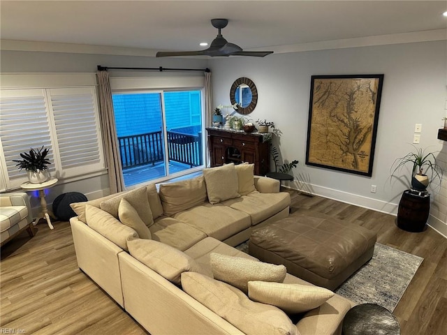 living room with ceiling fan, wood-type flooring, and ornamental molding