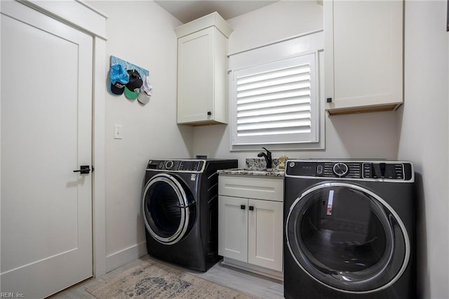 washroom with cabinets, washer / dryer, sink, and light hardwood / wood-style flooring