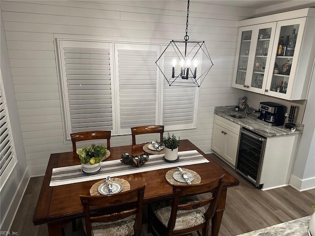 dining area with dark wood-type flooring, wooden walls, and beverage cooler