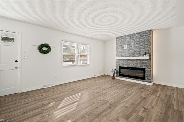 unfurnished living room with wood-type flooring and a fireplace