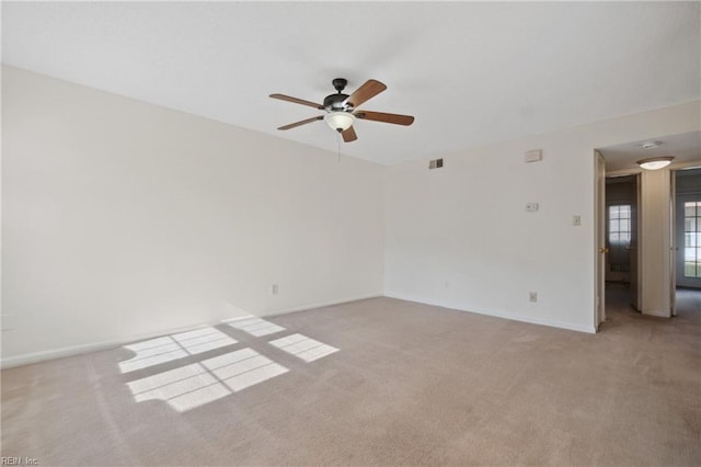 spare room with ceiling fan and light carpet