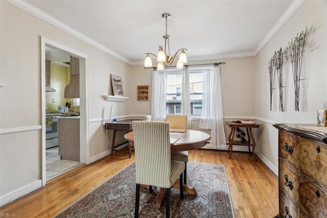 dining room with ornamental molding, light hardwood / wood-style flooring, and a notable chandelier