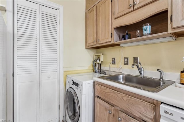 washroom with cabinets, sink, and washer / dryer