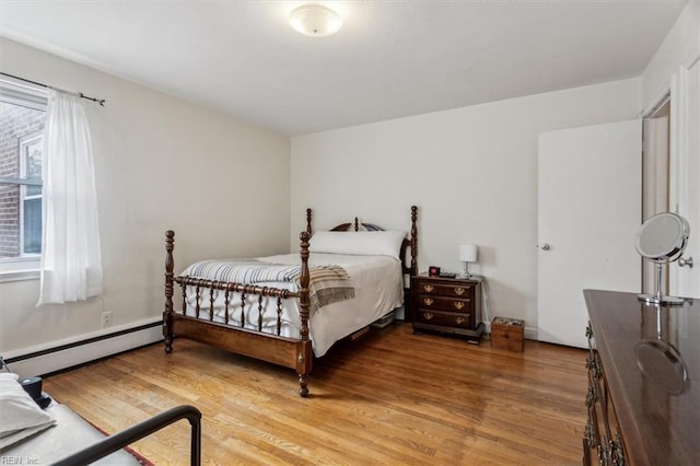 bedroom with a baseboard radiator and hardwood / wood-style flooring