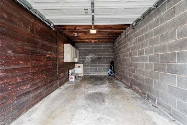 garage with a garage door opener and wood walls