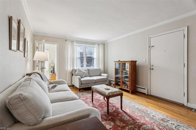 living room featuring a baseboard heating unit, light hardwood / wood-style floors, and crown molding