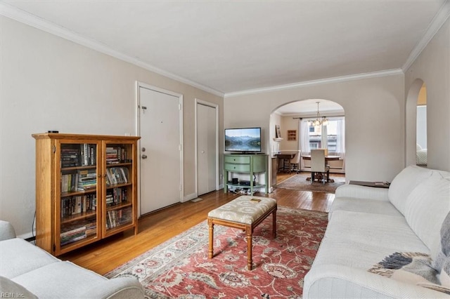 living room featuring hardwood / wood-style flooring, ornamental molding, and a notable chandelier