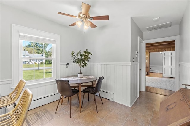 dining area featuring ceiling fan, baseboard heating, and light tile patterned flooring