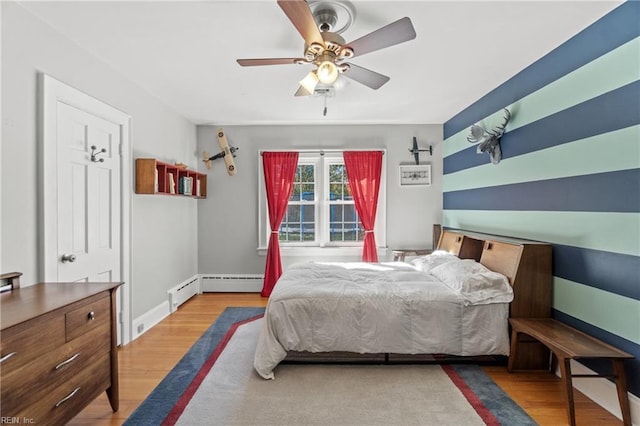 bedroom featuring ceiling fan, light wood-type flooring, and a baseboard radiator