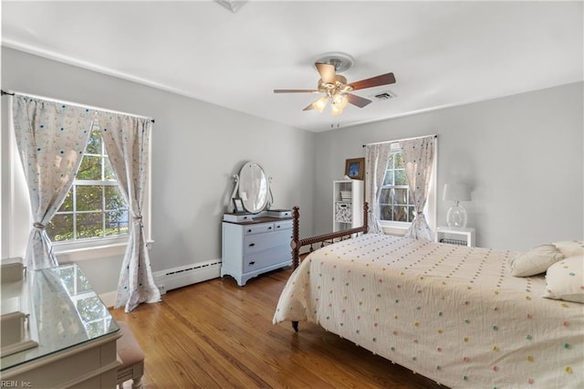 bedroom featuring a baseboard heating unit, ceiling fan, and wood-type flooring