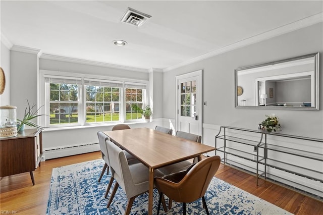 dining space featuring a baseboard heating unit, light hardwood / wood-style flooring, crown molding, and a healthy amount of sunlight