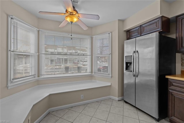 kitchen with ceiling fan, stainless steel fridge, dark brown cabinets, and light tile patterned floors