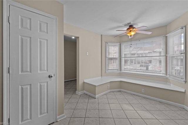 unfurnished room featuring ceiling fan, a healthy amount of sunlight, and light tile patterned floors