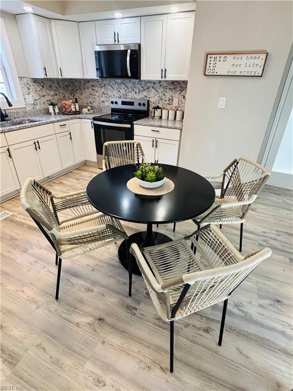 kitchen featuring sink, white cabinets, light stone countertops, and appliances with stainless steel finishes