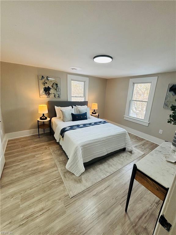 bedroom with light wood-type flooring and multiple windows