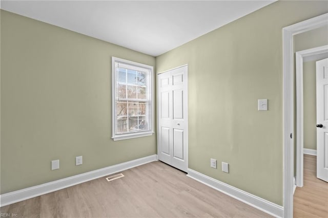 unfurnished bedroom featuring a closet and light hardwood / wood-style flooring