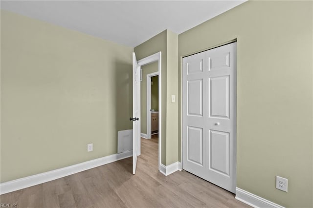 unfurnished bedroom featuring a closet and light wood-type flooring